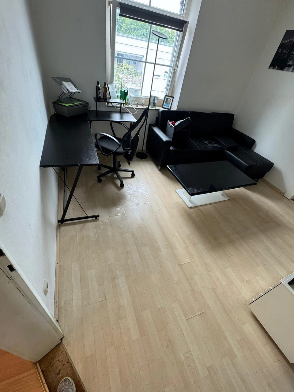 Aufgeräumtes Wohnzimmer mit Schreibtisch und Sofa nach einer Wohnungsentrümpelung