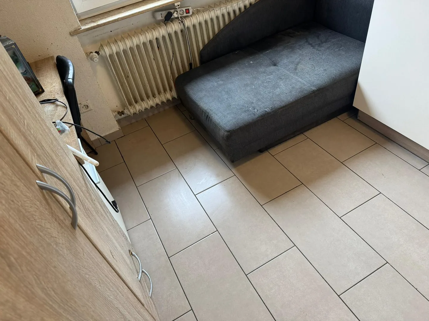 Wohnküche nach der Räumung mit freier Liege und leerem Fliesenboden